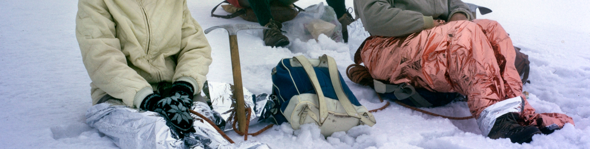 Les jambes enveloppées dans du film plastique, la cordée se repose dans la neige Suisse, 1966 Photographe:in : Dölf Reist © Musée Alpin Suisse